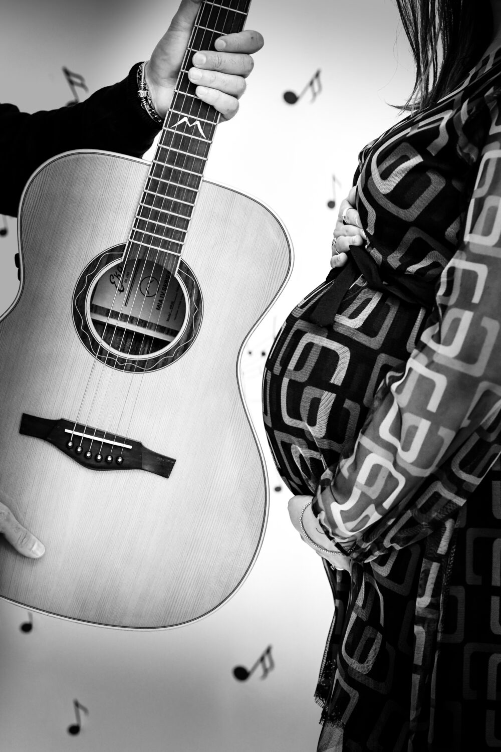 Foto artistica maternità in bianco e nero con chitarra classica in studio
