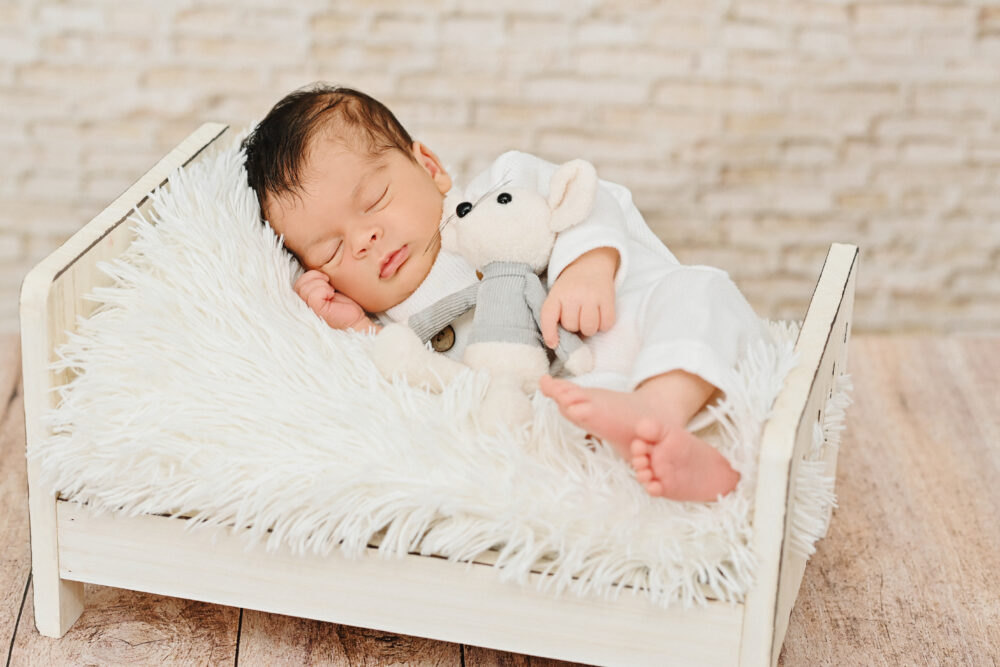 Fotografo neonati Brindisi neonato sveglio sul set con peluche bianco