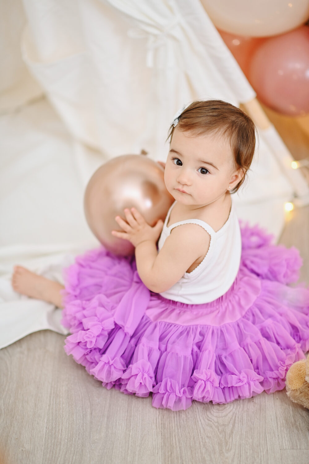 Bambina gioca con palloncini oro durante il servizio fotografico
