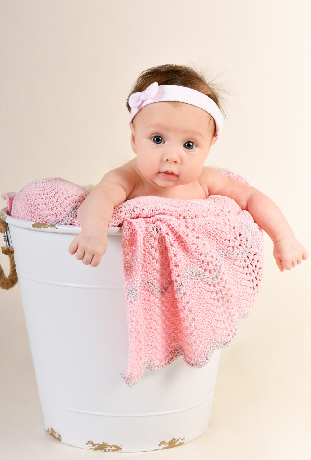 Ritratto neonata in studio fotografico a Brindisi con dettagli rosa