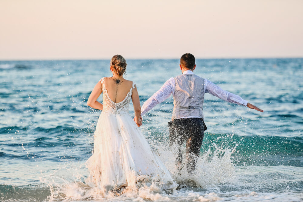 Foto di matrimonio spontanee sposi che corrono sulla spiaggia in Puglia