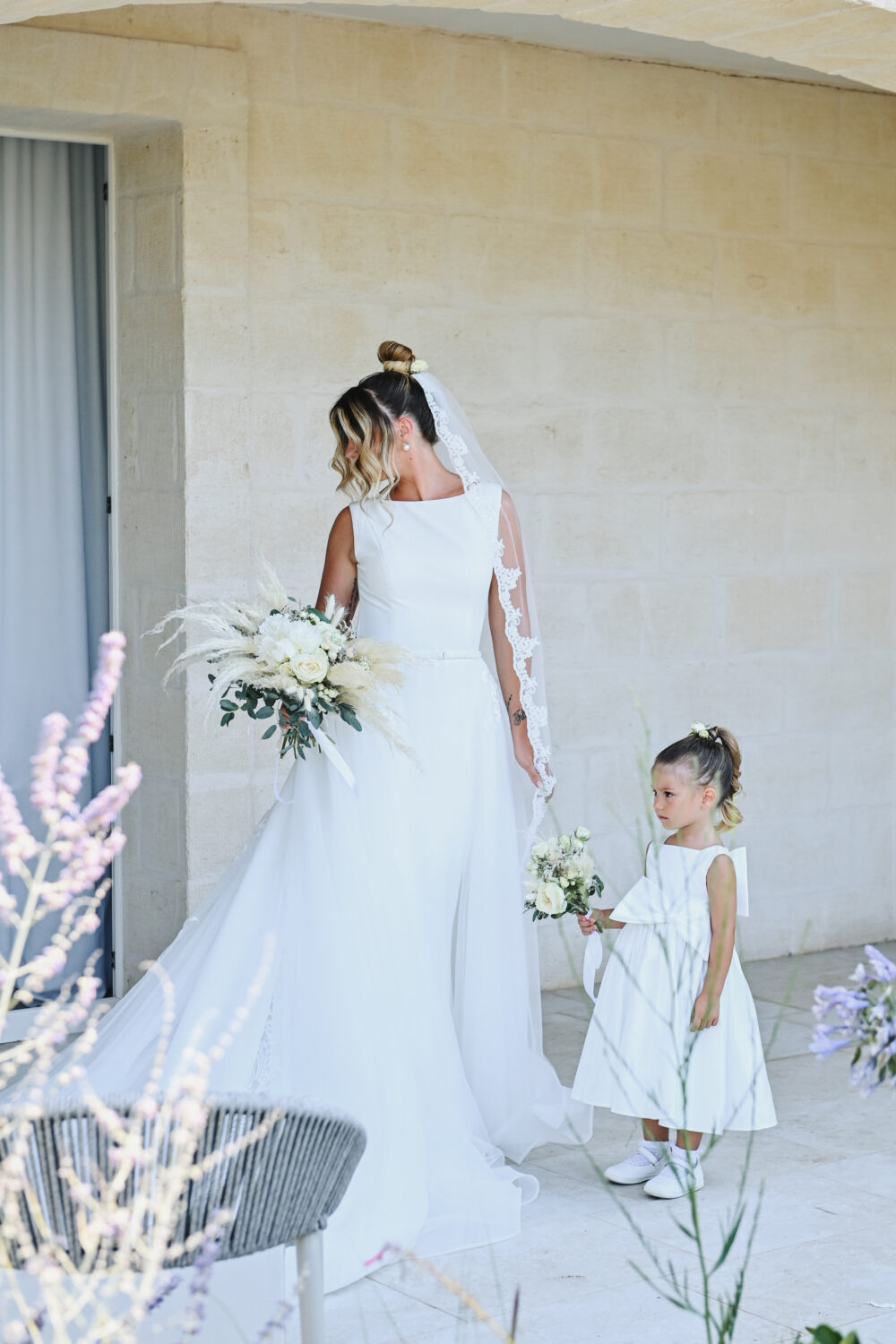 Sposa e damigella bimba paggetta camminano insieme prima del rito