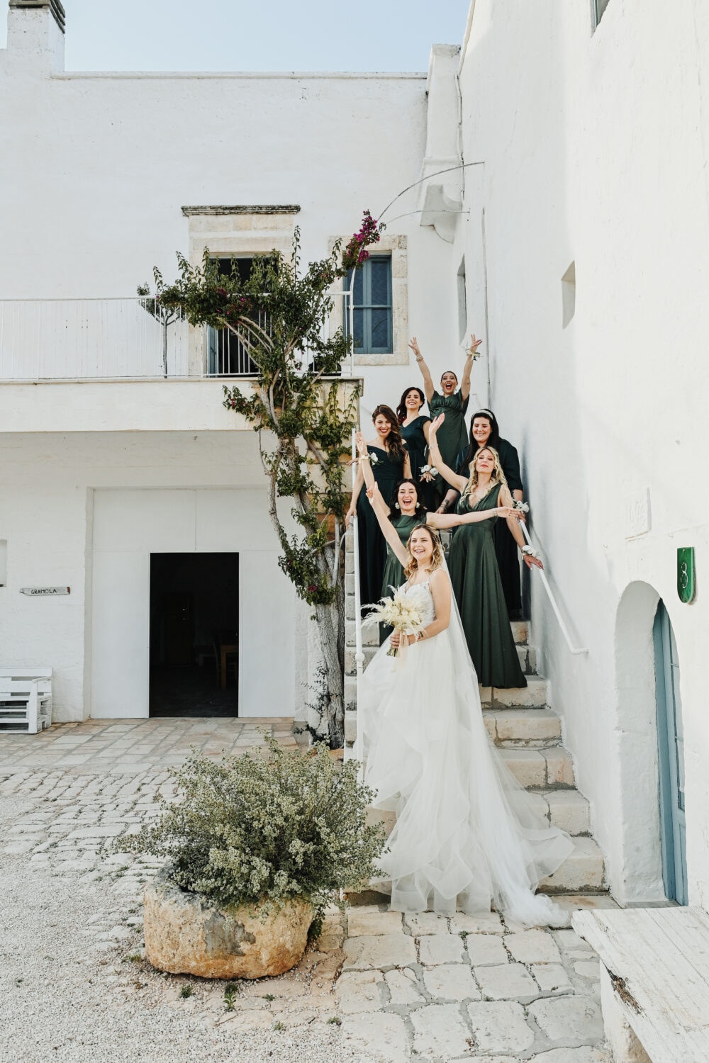 Sposa e damigelle si affacciano dalla casa tipica nei vicoli pugliesi