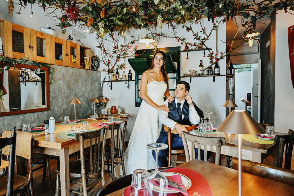 Sposi sorridenti al tavolo d onore durante il pranzo di matrimonio