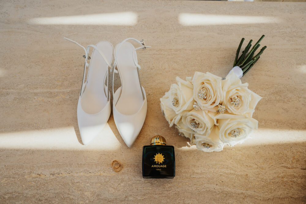 Dettaglio scarpe sposa eleganti e bouquet di rose bianche stabilizzate