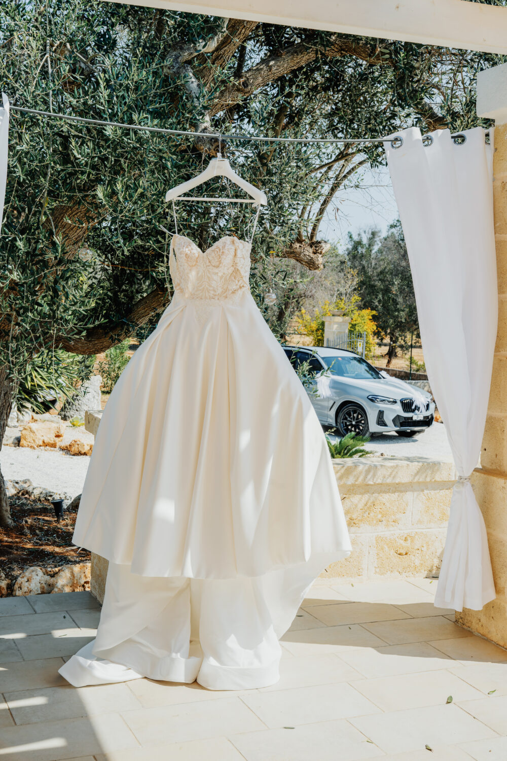 Abito da sposa appeso a un albero di ulivo foto originale in masseria