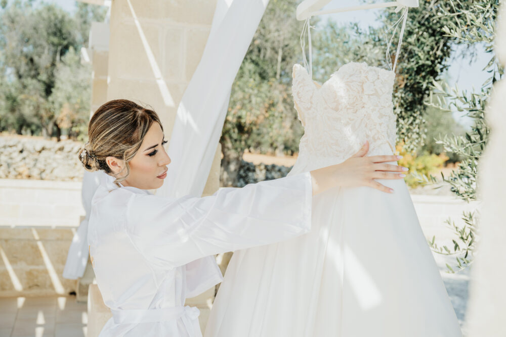 Sposa ammira il suo abito nuziale appeso prima della cerimonia Brindisi