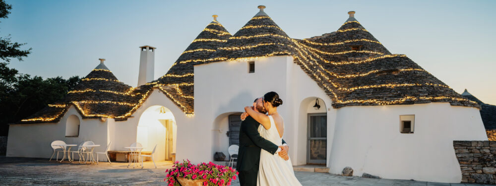 Fotografo matrimonio Alberobello sposi che si abbracciano davanti ai trulli