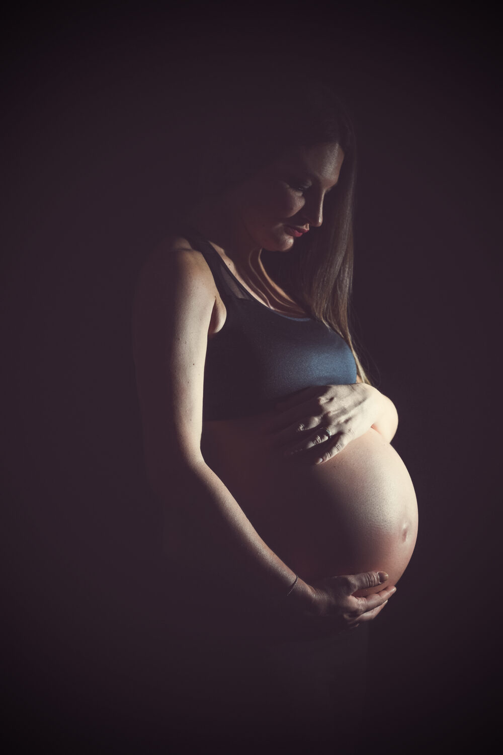 Fotografia artistica maternità silhouette con pancia in evidenza studio