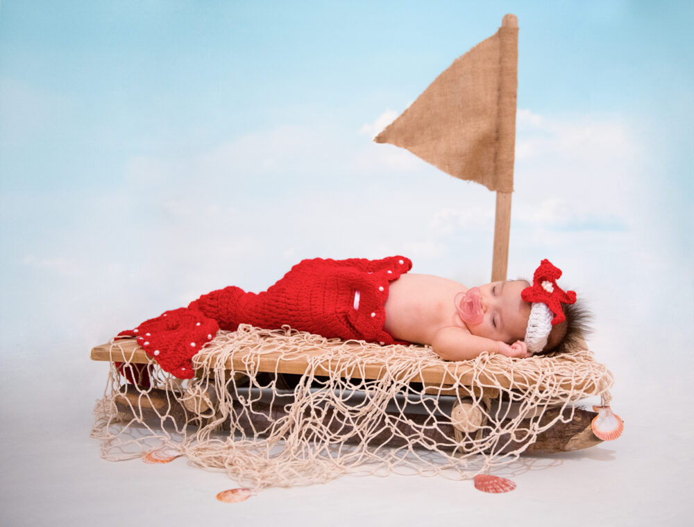 Fotografia neonati Puglia neonata con set a tema marino e barchetta