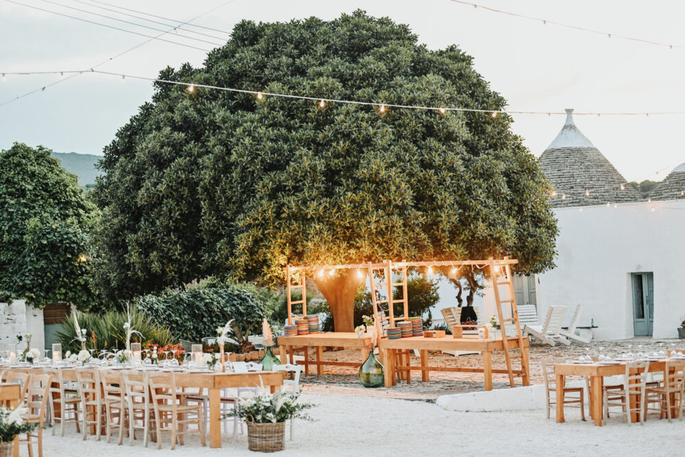 Cena di matrimonio all aperto sotto alberi illuminati in masseria Puglia