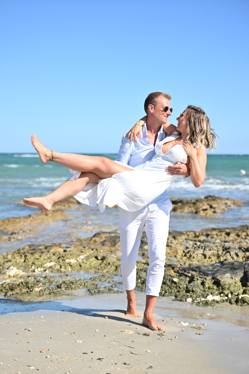 Fotografo matrimonio Salento sposo in braccio alla sposa sul mare