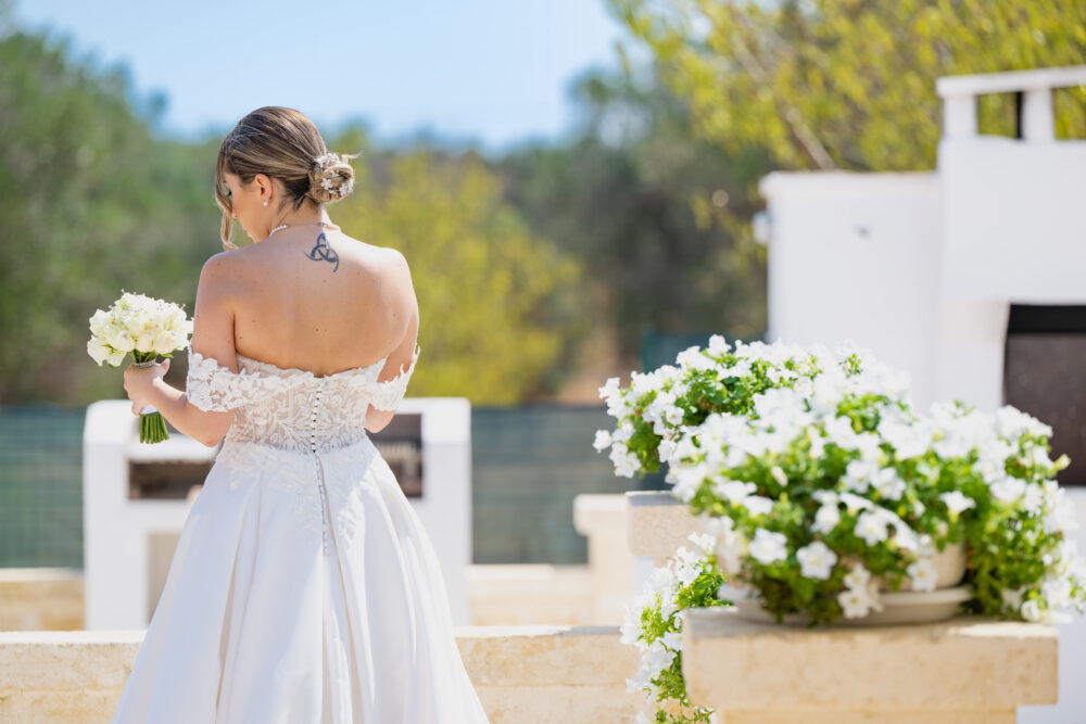 Dettaglio retro abito da sposa scollato durante il ricevimento in masseria