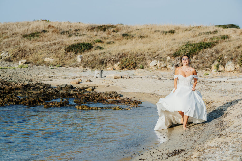 Inquadratura panoramica sposa sulla spiaggia deserta servizio post wedding