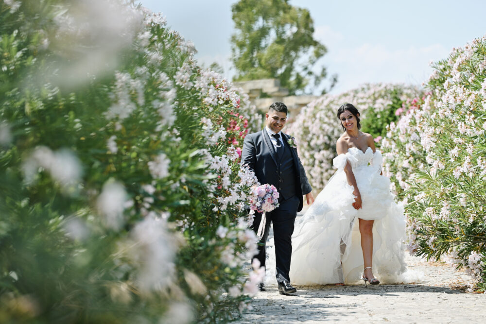 Sposi camminano in una corte storica in pietra servizio fotografico Puglia