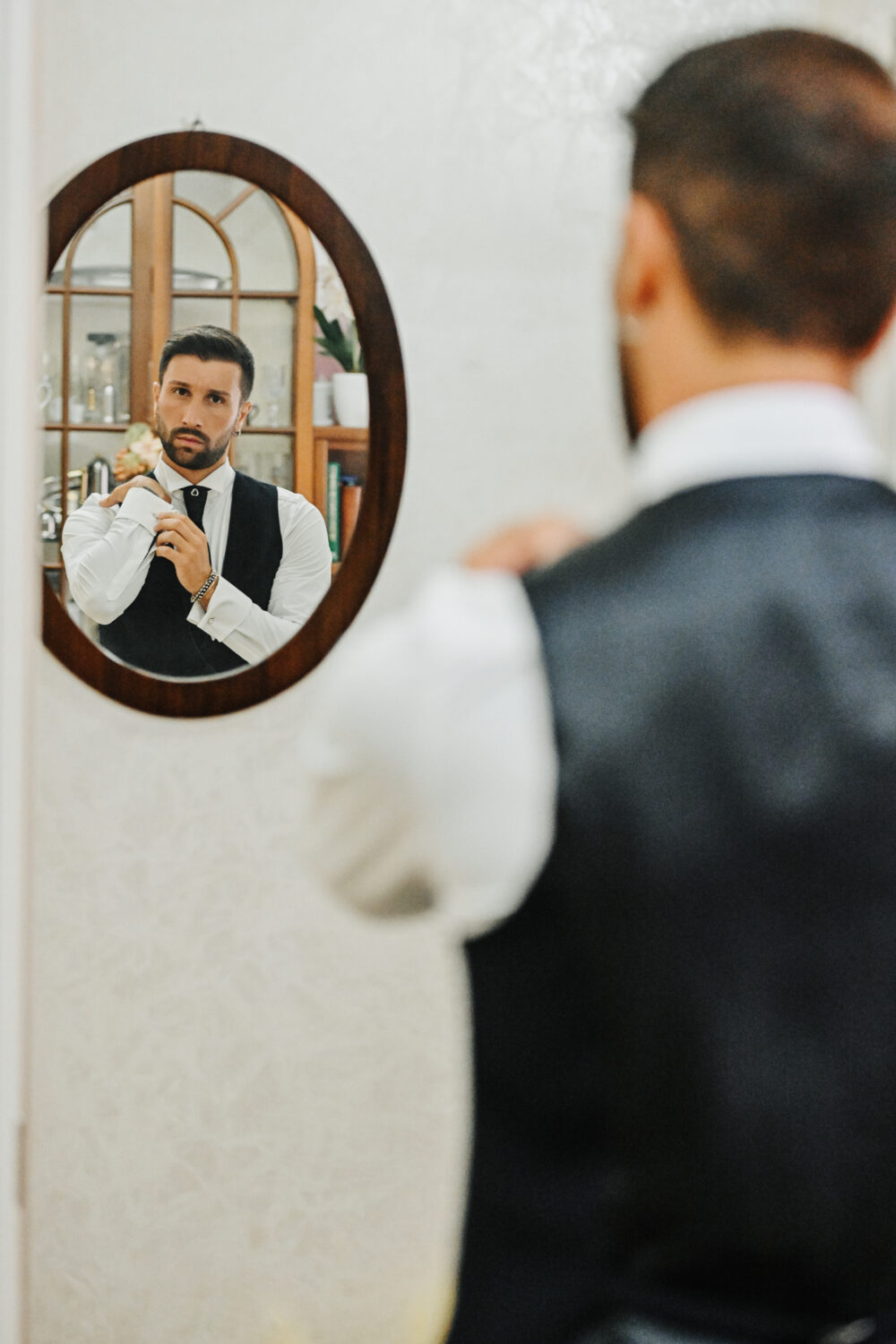 Sposo si guarda allo specchio durante i preparativi a casa a Brindisi