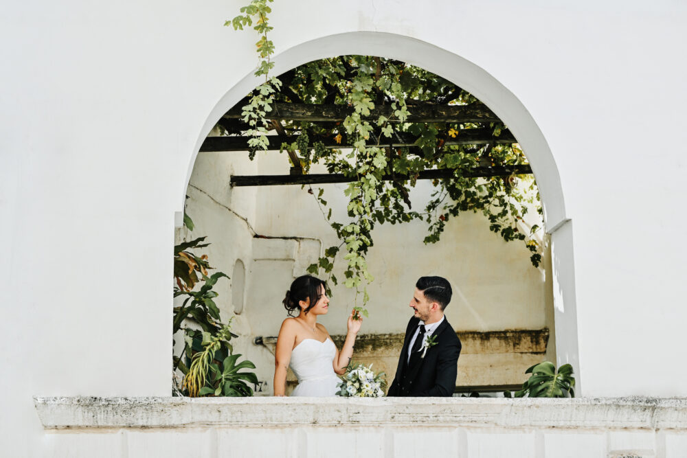 Sposi sotto un arco di pietra in una splendida location per matrimoni in Puglia