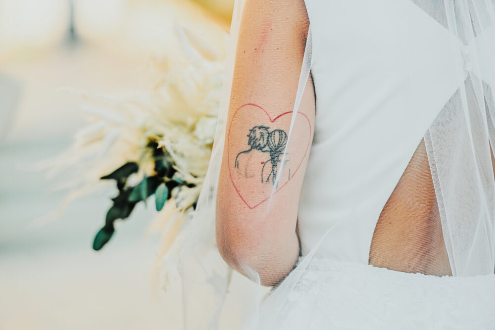 Dettaglio sposa moderna con tatuaggio e abito da sposa elegante