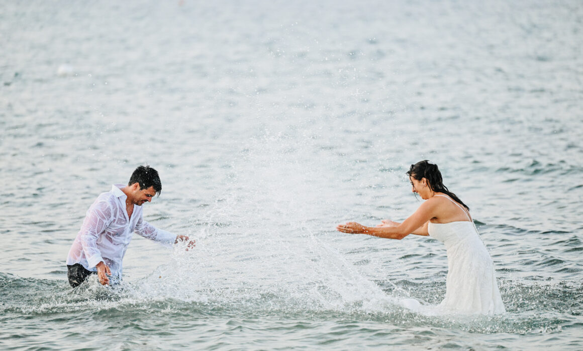 Video di matrimonio in Puglia, sposi che giocano in acqua al mare durante il reportage