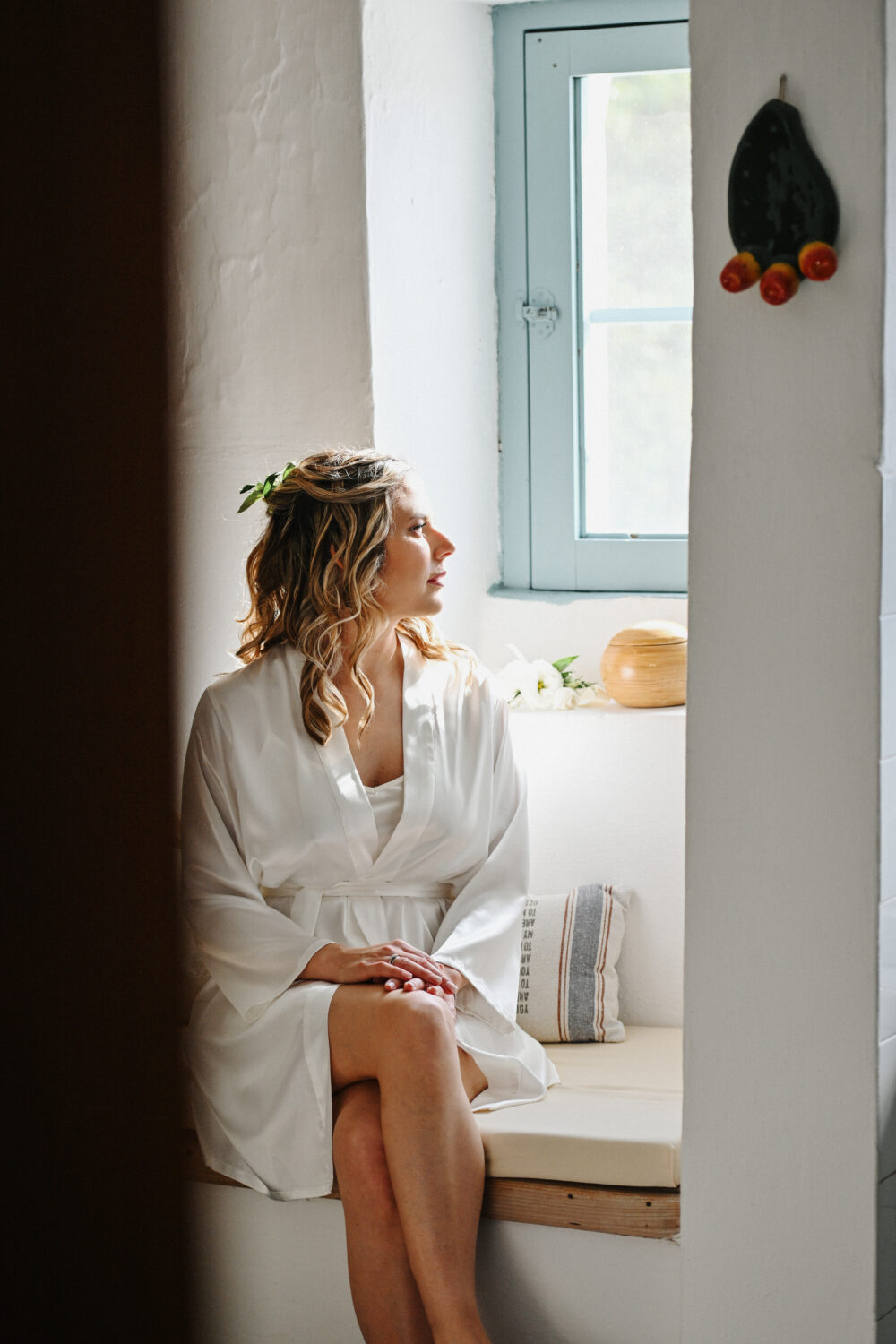 Fotografia matrimonio stile reportage sposa alla finestra durante i preparativi