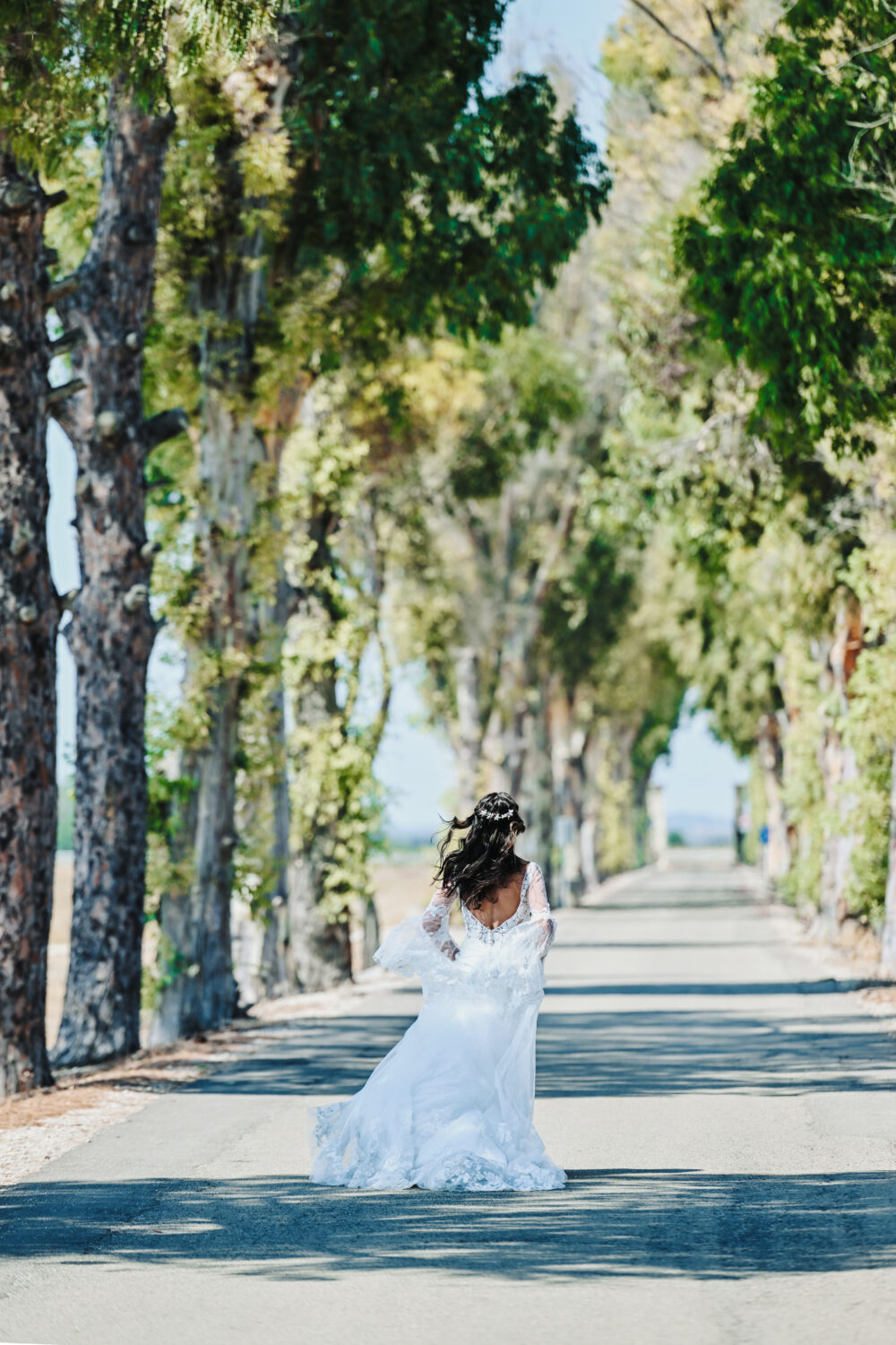 Fotografo matrimonio Brindisi sposa che cammina nel viale alberato