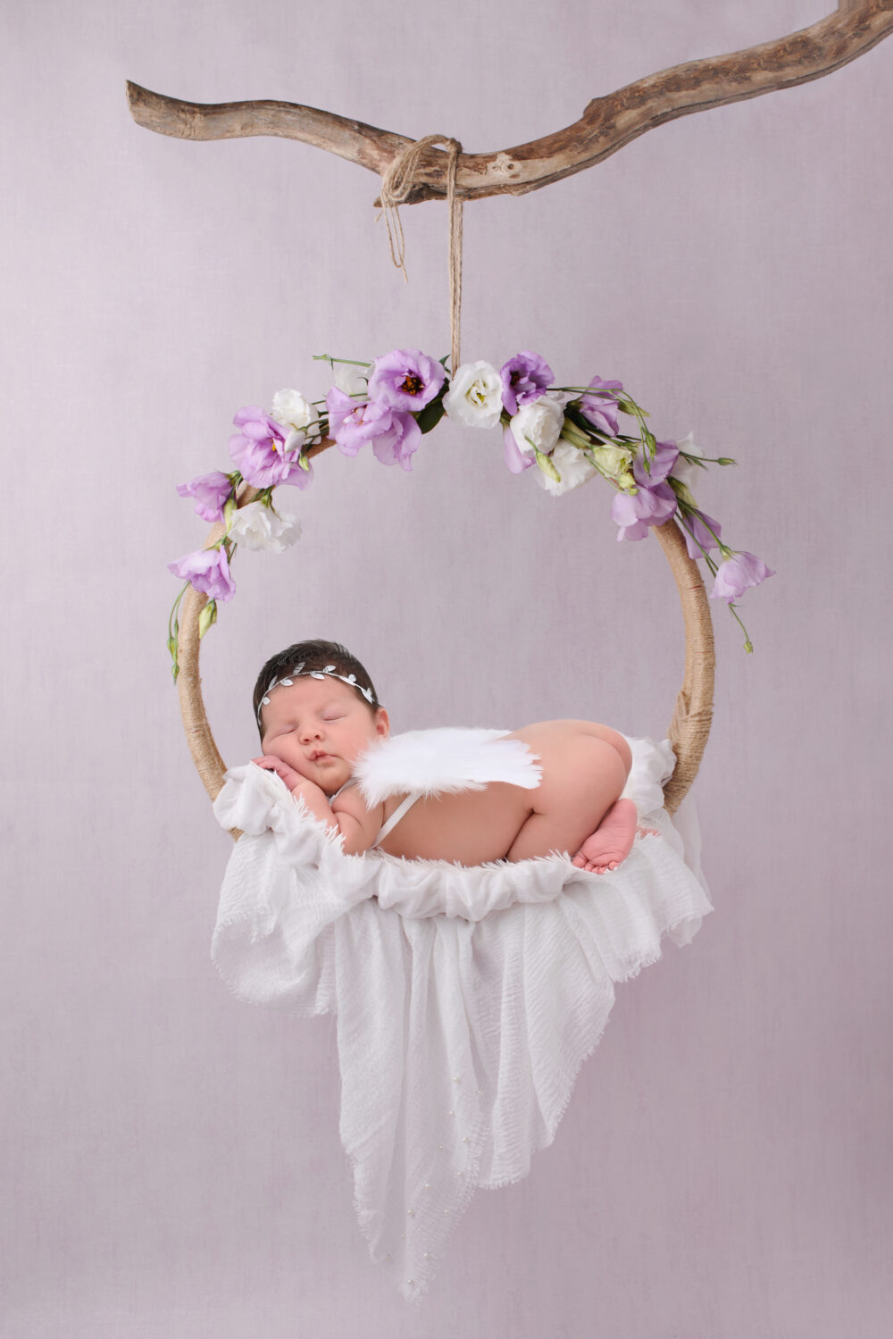 Servizio fotografico neonati Brindisi bimba addormentata su altalena di fiori